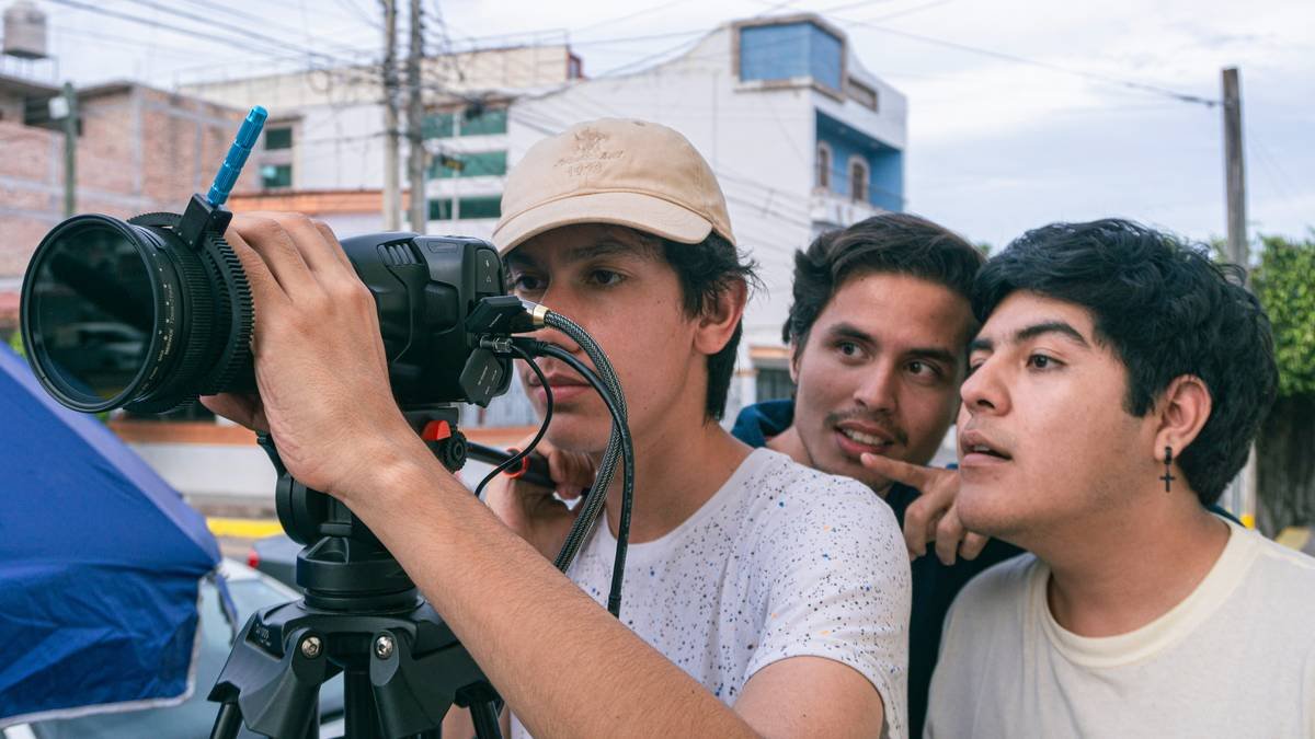 A documentary team discussing logistics amidst a forest backdrop