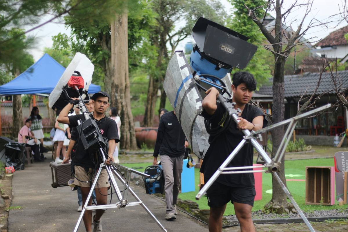 A film crew waiting out heavy rain at a flooded outdoor set.